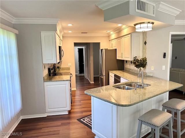 kitchen with white cabinetry, light stone counters, kitchen peninsula, and sink