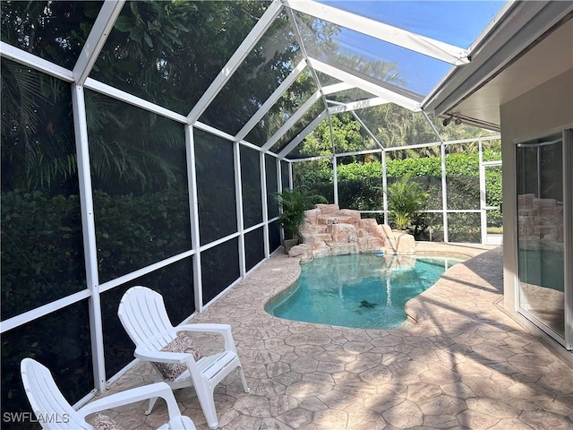 view of swimming pool featuring glass enclosure and a patio area