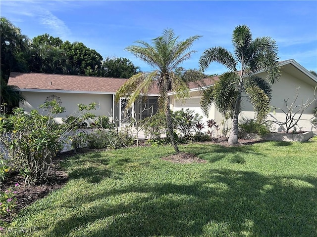 view of front of home with a garage and a front lawn