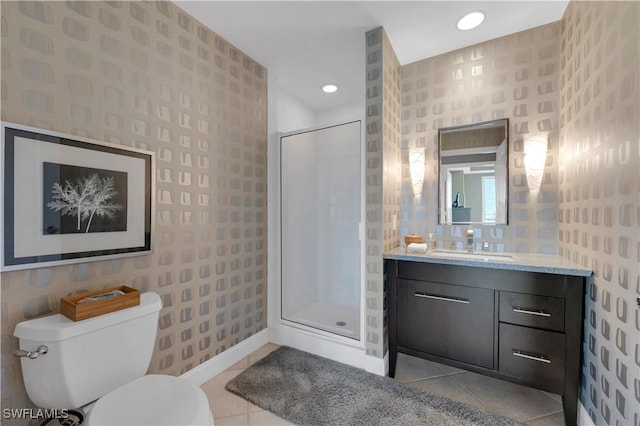 bathroom with a shower with door, vanity, tile patterned floors, and toilet