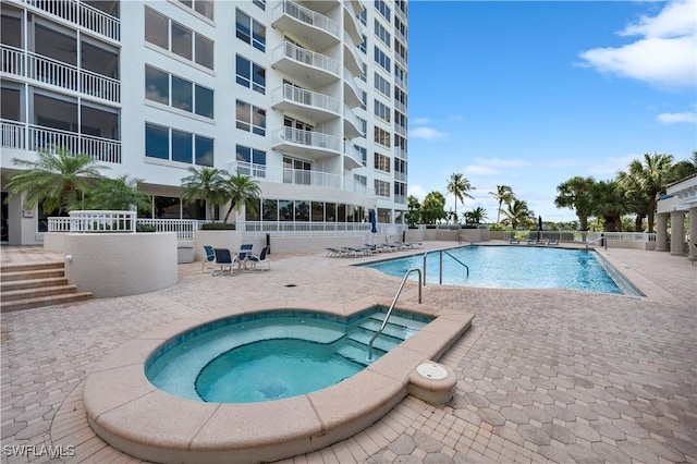 view of pool with a patio and a community hot tub