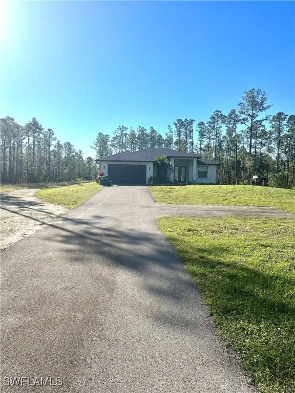 ranch-style home with a garage and a front yard