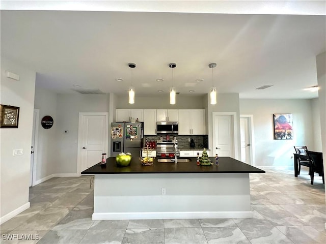 kitchen featuring a kitchen island with sink, hanging light fixtures, white cabinets, and stainless steel appliances