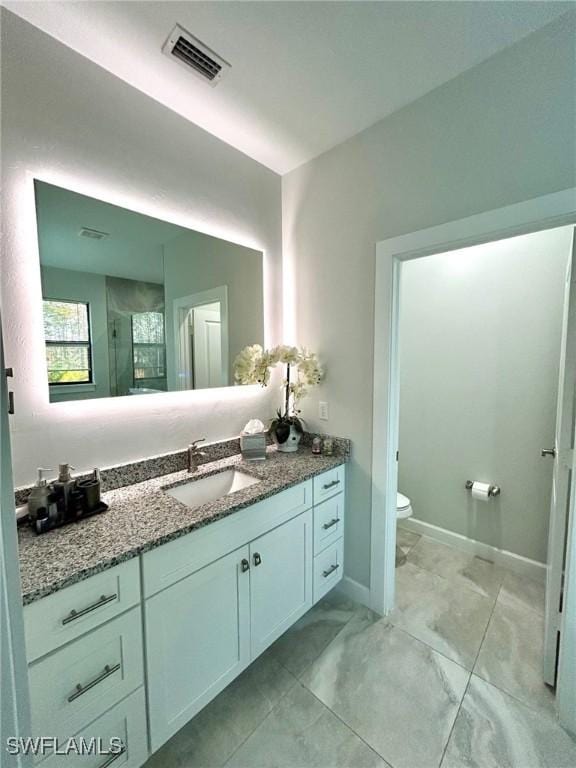 bathroom featuring walk in shower, vanity, and toilet