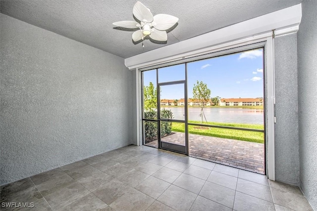 spare room featuring a water view and ceiling fan