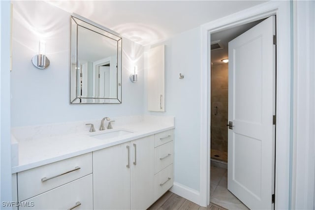 bathroom featuring a tile shower and vanity