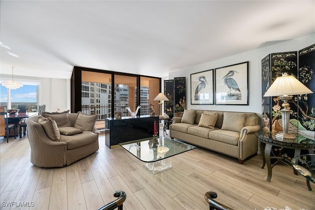 living room with an inviting chandelier and light hardwood / wood-style floors