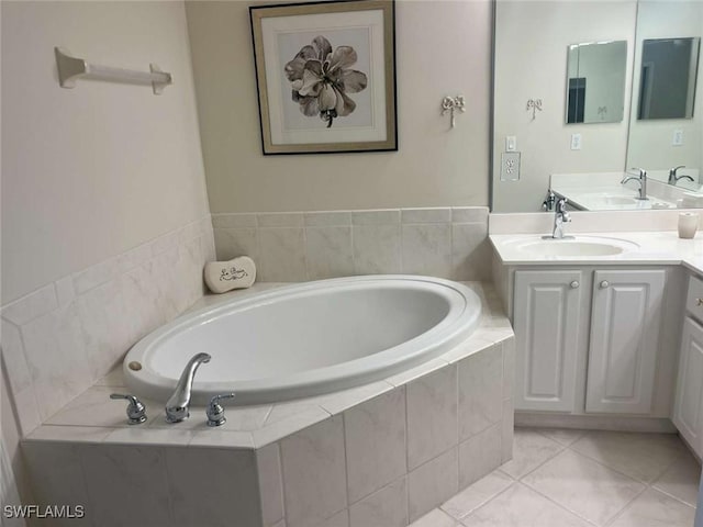 bathroom featuring tile patterned flooring, vanity, and tiled tub