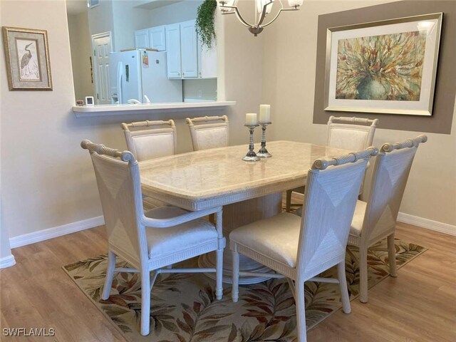 dining room with a notable chandelier and light hardwood / wood-style floors