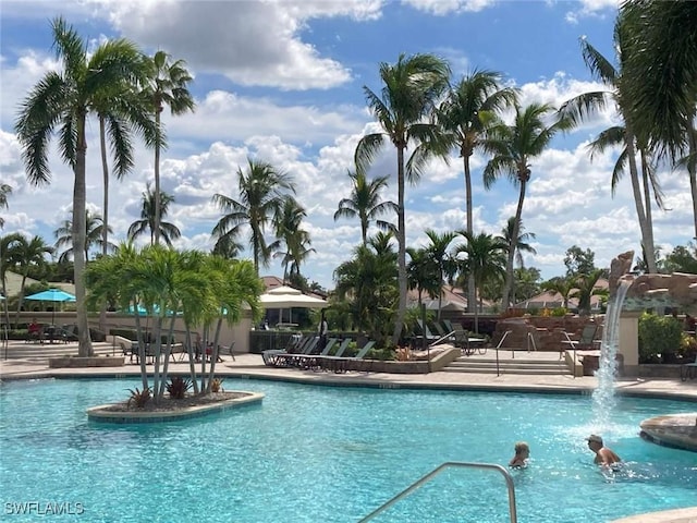 view of swimming pool with pool water feature and a patio area