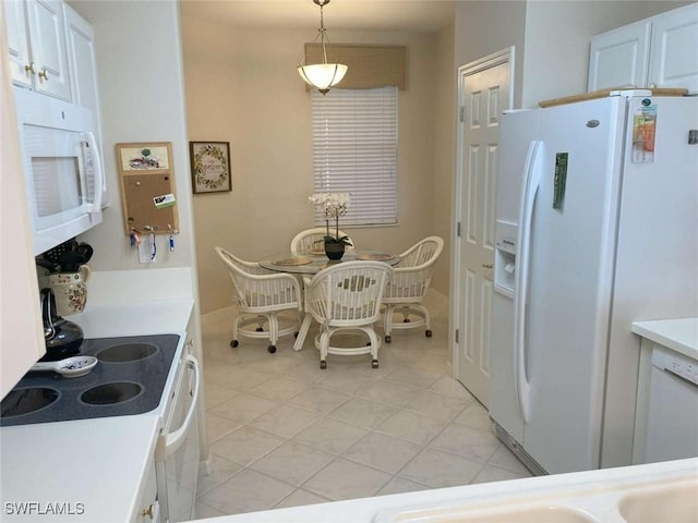 kitchen featuring white appliances, decorative light fixtures, white cabinetry, and light tile patterned flooring