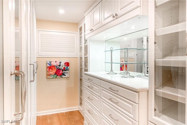 walk in closet with light wood-style flooring