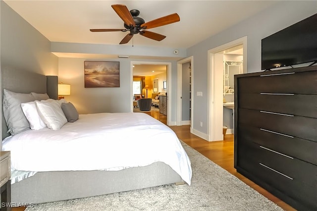 bedroom featuring hardwood / wood-style flooring, ensuite bath, and ceiling fan