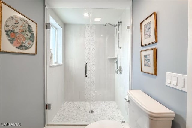 bathroom featuring a shower stall and toilet