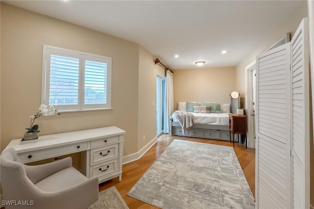 bedroom with recessed lighting, light wood-type flooring, baseboards, and built in study area