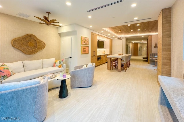 living room featuring visible vents, recessed lighting, a ceiling fan, and a tray ceiling