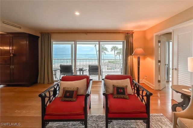 living area with a water view and light hardwood / wood-style floors