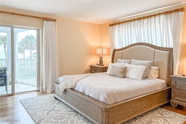 bedroom featuring access to exterior and wood finished floors