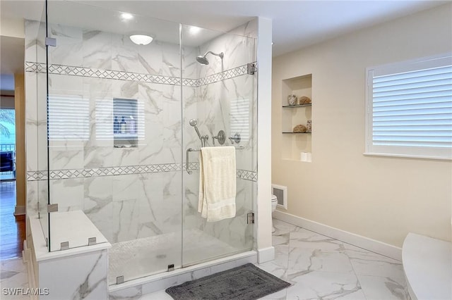 full bathroom featuring marble finish floor, built in shelves, a shower stall, and baseboards