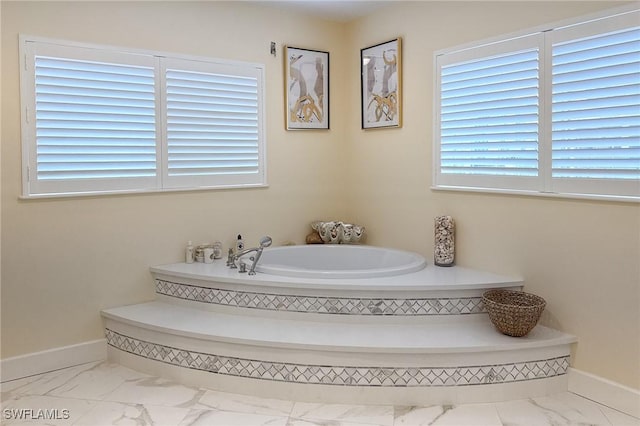 full bathroom with baseboards, marble finish floor, and a bath