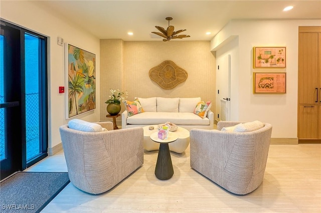 living room with a ceiling fan, light wood-style flooring, recessed lighting, and baseboards