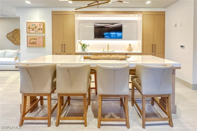 bar with light brown cabinets and sink