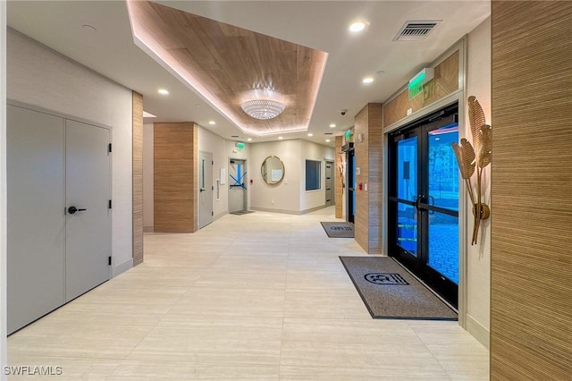 corridor with visible vents, baseboards, light tile patterned floors, recessed lighting, and a raised ceiling