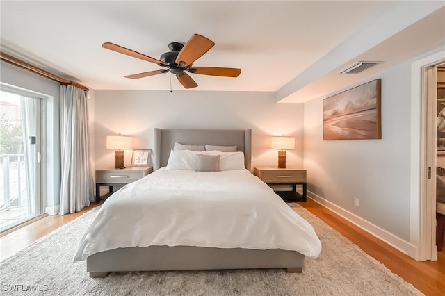 bedroom featuring visible vents, access to outside, wood finished floors, baseboards, and ceiling fan