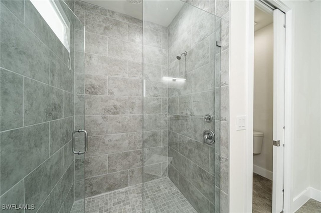 bathroom featuring an enclosed shower and toilet