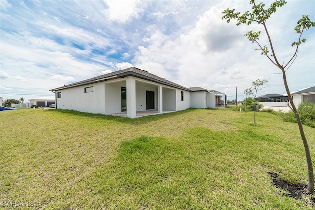 back of property featuring a lawn and a patio area