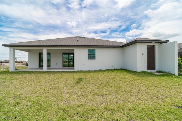 rear view of property with a lawn and a patio