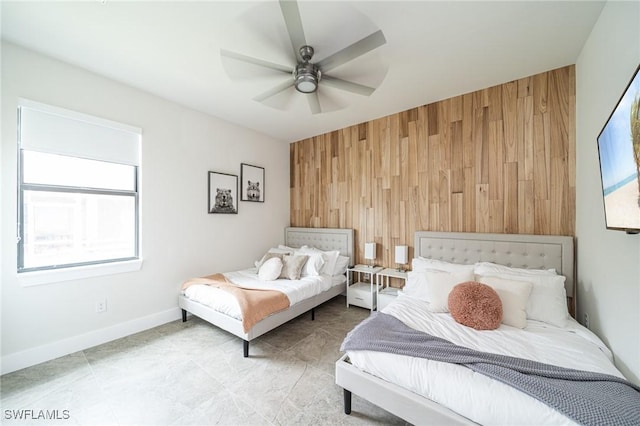 bedroom featuring ceiling fan and wood walls