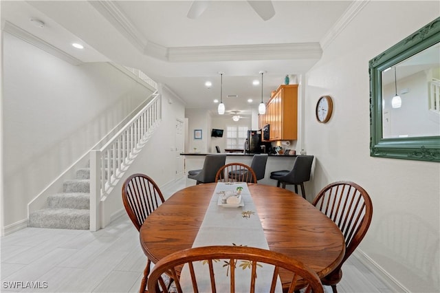 dining area with ceiling fan and crown molding