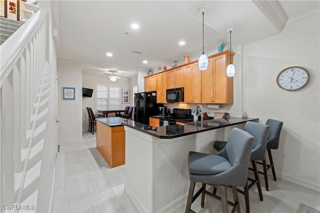 kitchen featuring ceiling fan, kitchen peninsula, decorative light fixtures, a breakfast bar, and black appliances