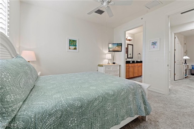 bedroom with ceiling fan, ensuite bathroom, and light colored carpet