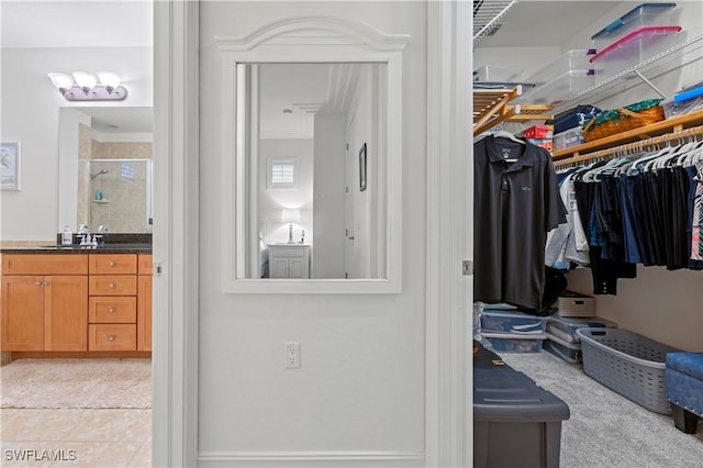 walk in closet featuring light tile patterned flooring and sink