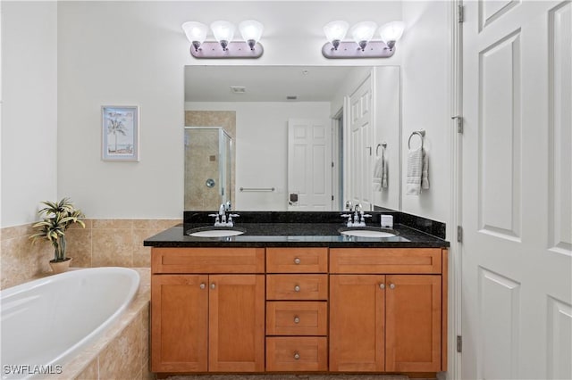 bathroom featuring vanity and independent shower and bath