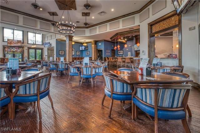 interior space with a high ceiling, dark hardwood / wood-style flooring, decorative columns, and crown molding