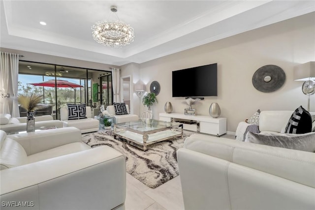 living room featuring crown molding, an inviting chandelier, and a raised ceiling