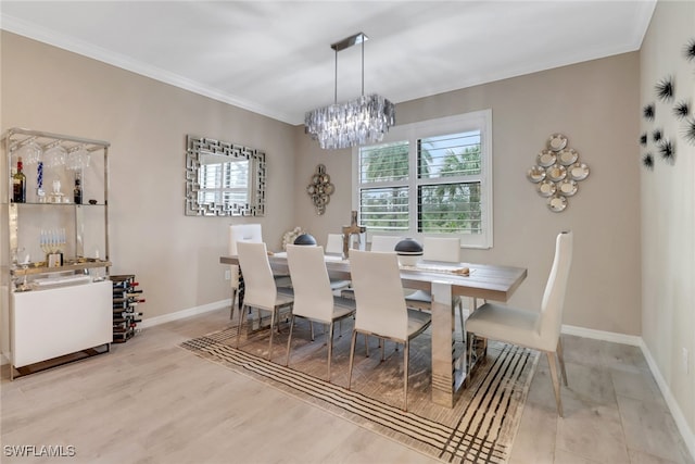 dining room featuring light hardwood / wood-style floors, ornamental molding, and a notable chandelier