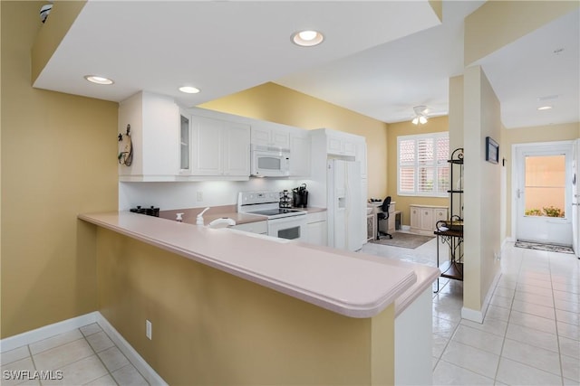 kitchen with white appliances, kitchen peninsula, ceiling fan, light tile patterned floors, and white cabinetry