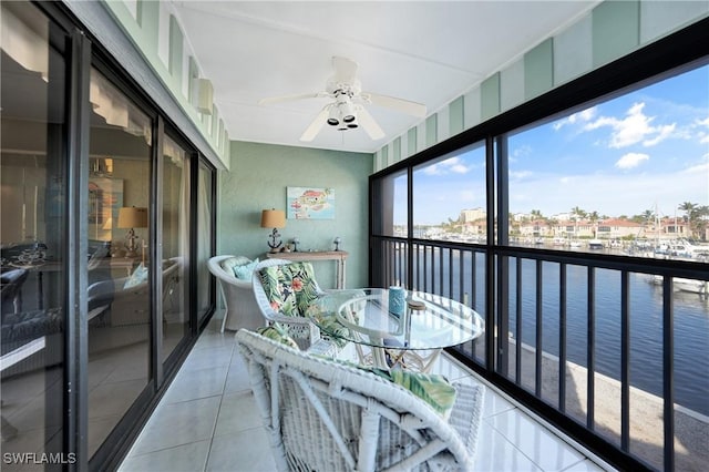 sunroom with a water view and ceiling fan