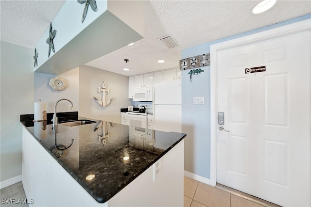 kitchen featuring kitchen peninsula, white appliances, white cabinetry, and sink