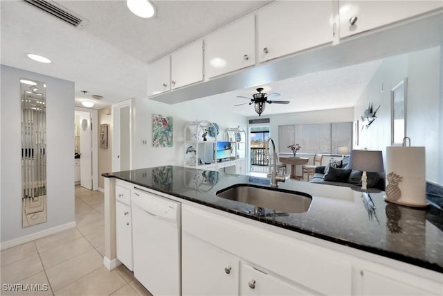 kitchen featuring dark stone countertops, white cabinetry, dishwasher, and sink