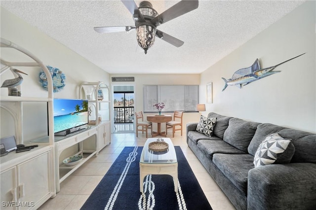 living room featuring ceiling fan, light tile patterned floors, and a textured ceiling