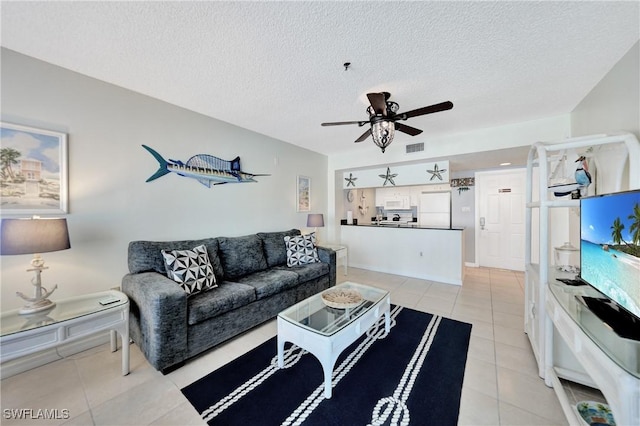 tiled living room with a textured ceiling and ceiling fan