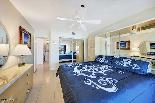 bedroom featuring ceiling fan, a closet, and light tile patterned floors