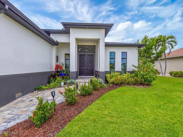 doorway to property featuring a lawn