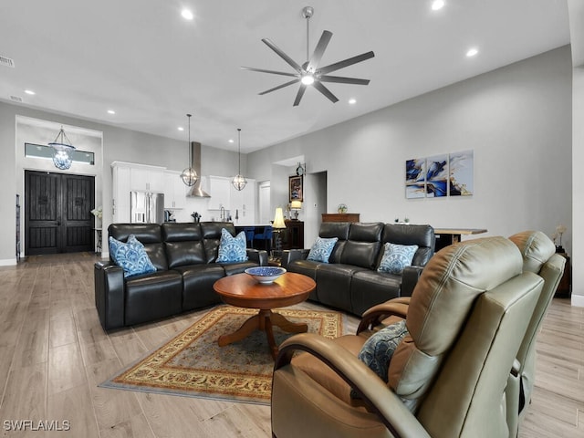 living room featuring ceiling fan and light hardwood / wood-style flooring