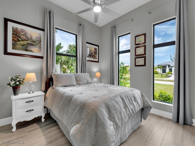 bedroom with multiple windows, light hardwood / wood-style flooring, and ceiling fan